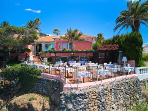 a restaurant with tables and chairs in front of a house at Inn & Art Madeira in Caniço