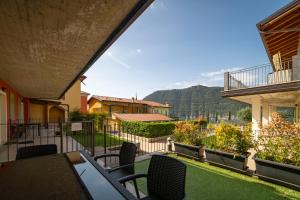 een balkon met stoelen en uitzicht op een huis bij PARADISE in Sale Marasino