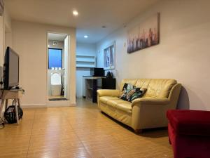 sala de estar con sofá y TV en Mt Eden Tidy Unit B, en Auckland