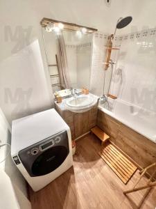 uma pequena casa de banho com um lavatório e uma banheira em EL CUBANITO ATHENA - EXOTISME CUBAIN - 2 Chambres - Parking Privé - Proximité Gare - BUSINESS & FAMILY FRIENDLY em Cergy