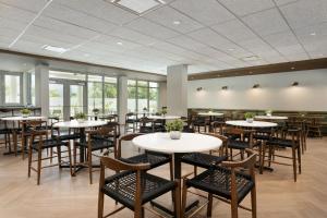 una sala da pranzo con tavoli, sedie e finestre di Fairfield by Marriott Luquillo Beach a Luquillo