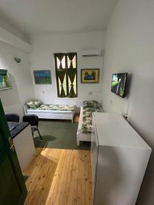 a room with two beds and a refrigerator in it at Guesthouse Hurma Rooms in Sarajevo