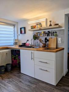 a kitchen with white cabinets and a counter top at private gemütliche Einliegerwohnung in Enkenbach-Alsenborn