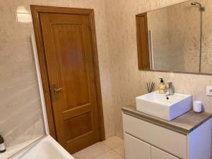 a bathroom with a sink and a mirror and a tub at Casa Coveliño in Poio