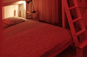 1 dormitorio con cama roja y escalera en San Luca, en Bolonia