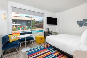 a bedroom with a bed and a room with a pool at Aloft Denver North Westminster in Westminster