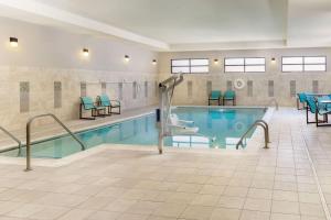 a swimming pool with chairs and tables in a building at Residence Inn by Marriott Youngstown Warren/Niles in Niles