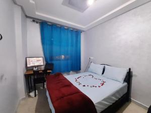 a bedroom with a bed and a desk with a computer at Chambre calme et relaxante à centre ville Agadir in Agadir