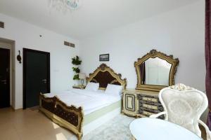 1 dormitorio con 1 cama con espejo y silla en 3 bedroom Luxury Suite apartment near JBR Beach, en Dubái