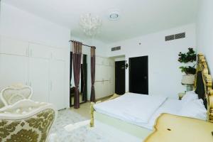 1 dormitorio con 1 cama, 1 silla y 1 lámpara de araña en 3 bedroom Luxury Suite apartment near JBR Beach, en Dubái