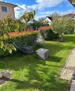 duas cadeiras e uma caixa num quintal com flores em "TiMia" Nähe Europa Park und Rulantica Rust em Mahlberg