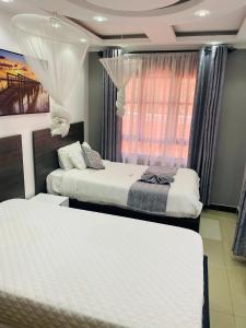 1 Schlafzimmer mit 2 Betten und einem Fenster in der Unterkunft SR Apartments Milimani, Kisumu in Kisumu