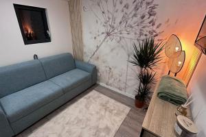 sala de estar con sofá azul y mesa en LA VILLA DEKO - Studio indépendant, en Beuvry