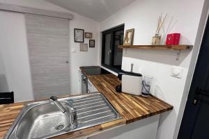 a kitchen with a sink and a wooden counter top at LA VILLA DEKO - Studio indépendant in Beuvry