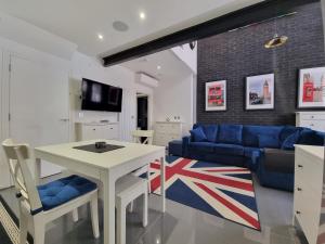 a living room with a table and a blue couch at Deluxe Townhouse Zone 1 Brick Lane in London