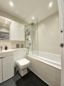 a white bathroom with a toilet and a shower at Deluxe Townhouse Zone 1 Brick Lane in London