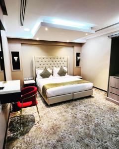 ein Schlafzimmer mit einem großen Bett und einem Schreibtisch in der Unterkunft اصالة الشروق للشقق المخدومه in Khobar