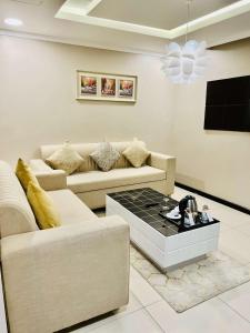 Sala de estar con 2 sofás y mesa de centro en اصالة الشروق للشقق المخدومه, en Al Khobar