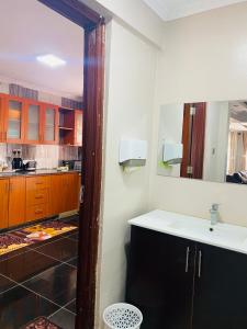 a kitchen with a sink and a mirror at SR Apartments Milimani, Kisumu in Kisumu