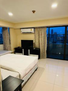 Habitación de hotel con 2 camas y ventana grande. en Omni Tower Sukhumvit Nana by Direct Rooms en Bangkok