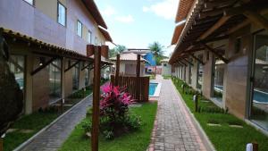 a walkway between two buildings with a pool at Aconchego da Jandaia in Imbassai