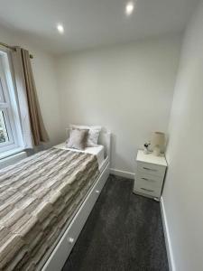 a white bedroom with a bed and a window at Lovely Two Bedroom House in Central Kidlington in Kidlington