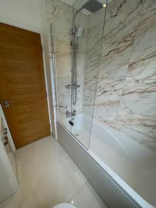 een badkamer met een douche, een bad en een toilet bij Lovely Two Bedroom House in Central Kidlington in Kidlington