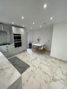 a white kitchen with a table and a dining room at Lovely Two Bedroom House in Central Kidlington in Kidlington