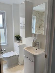 Baño blanco con aseo y lavamanos en Lovely Two Bedroom House in Central Kidlington, en Kidlington
