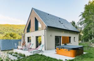 a small white house with two chairs on a patio at L’Éterle, maison de montagne in Aucun