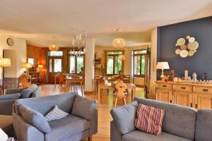 uma sala de estar com 2 sofás e uma sala de jantar em Le Manoir des Sens - Forêt de Bergheim em Thannenkirch