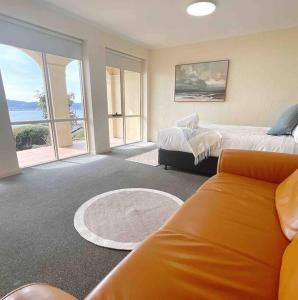 Habitación grande con 2 camas y sofá en Millions View - Hobart, en Sandy Bay