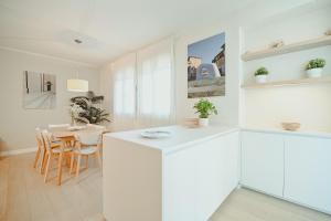 a kitchen and dining room with white cabinets and a table at Angolo a Corte in Pietrasanta +34 photos