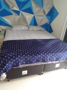 Bett in einem Zimmer mit einer blau-weißen Wand in der Unterkunft Sol & Mar Hostel in Praia Grande