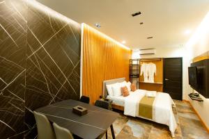 um quarto de hotel com uma cama, uma mesa e uma televisão em Rockfort Hotel em Cotabato