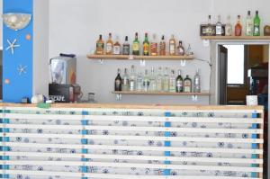 ソゾポルにあるHotel Sozopolの棚にアルコールのボトルを用意したバー