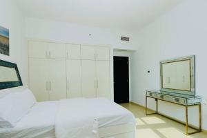 Dormitorio blanco con espejo y cama en 3 bedroom Luxury Suite apartment near JBR Beach, en Dubái
