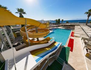 una piscina con un tobogán y una piscina en Petunya Beach Resort, en Ortakent