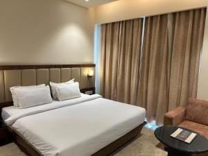 um quarto de hotel com uma cama e uma cadeira em The Imperial Prime Clarks inn Suites, Bhilwara em Bhīlwāra