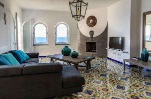 uma sala de estar com um sofá e uma televisão em Amore Rentals - Villa dei Sogni em Massa Lubrense