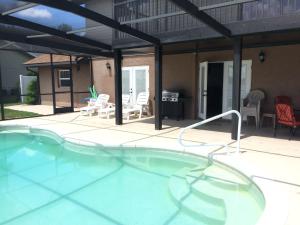 una gran piscina con sillas y un patio en Lake Whistler Hideaway, en Auburndale