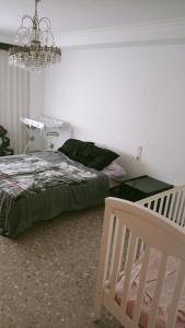 a bedroom with a bed and a chandelier at Apartamento Retro in Sagunto