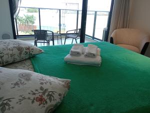 uma cama verde com duas toalhas em cima em Studio 811 em Marília