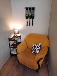 um sofá laranja com uma almofada na parede em Zemgales 13 em Iecava