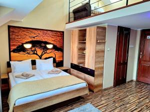 a bedroom with a bed with a painting on the wall at Angyal Apartman Gyula in Gyula