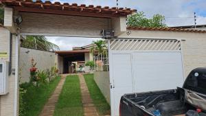 une porte de garage blanche sur une maison avec une cour dans l'établissement Casa de Bênçãos, à Santo Antônio do Rio das Pedras