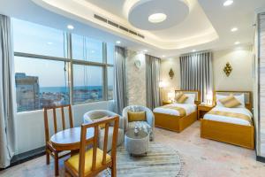 Habitación de hotel con 2 camas, mesa y sillas en فندق النجم الأزرق - Blue star hotel en Yeda