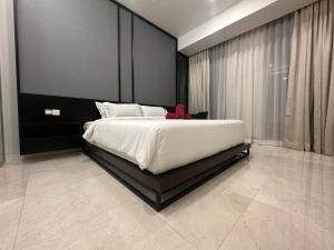 Un dormitorio con una cama grande con un osito de peluche rojo. en Tropicana The Residences KLCC VIEW 53F infinity Pool, en Kuala Lumpur