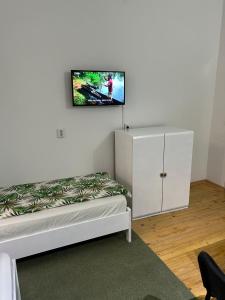una stanza con un letto e una TV a parete di Guesthouse Hurma Rooms a Sarajevo