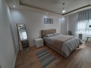 um quarto com uma cama, um espelho e uma cómoda em Apartment in the heart of Tirana em Tirana